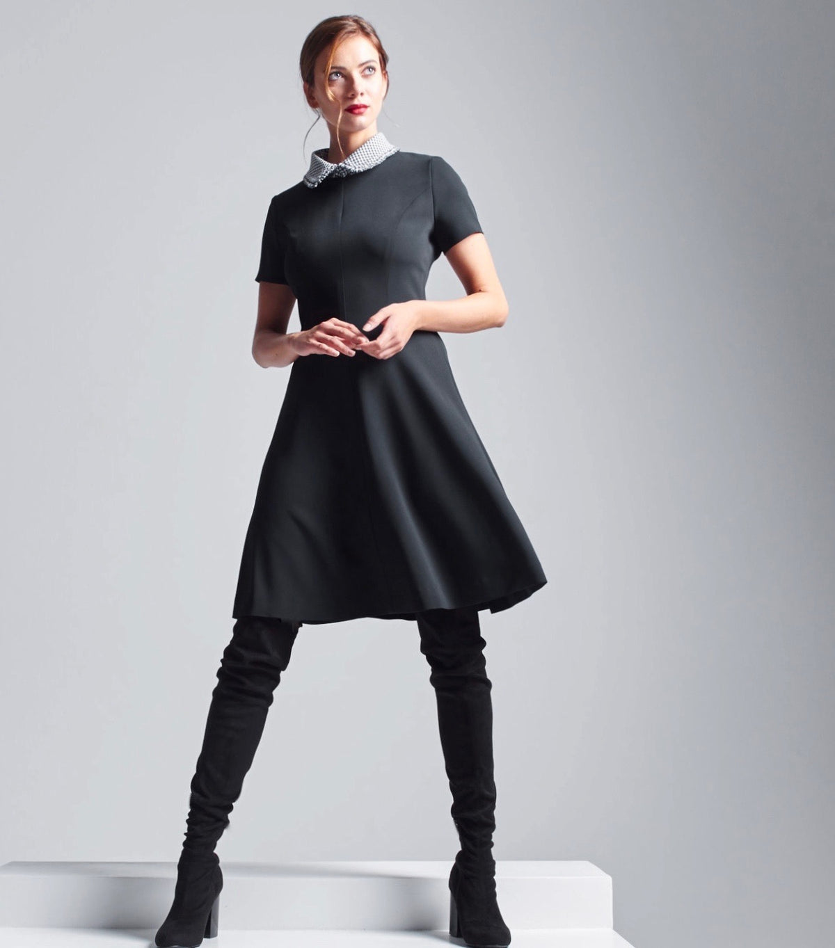 Das Model trägt den abnehmbaren Rüschenkragen in Pepita Muster kombiniert mit dem schwarzen Multiplyfashion A-Linien Kleid.