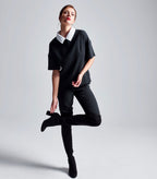 Das Model trägt den abnehmbaren Hemdkragen aus weißem Baumwoll-Jacquard kombiniert mit dem schwarzen Multiplyfashion Shift Oberteil und der anliegenden Multiplyfashion Hose.