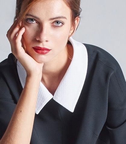 Das Model trägt den abnehmbaren Hemdkragen aus weißem Baumwoll-Jacquard kombiniert mit dem schwarzen Multiplyfashion Shift Oberteil. 