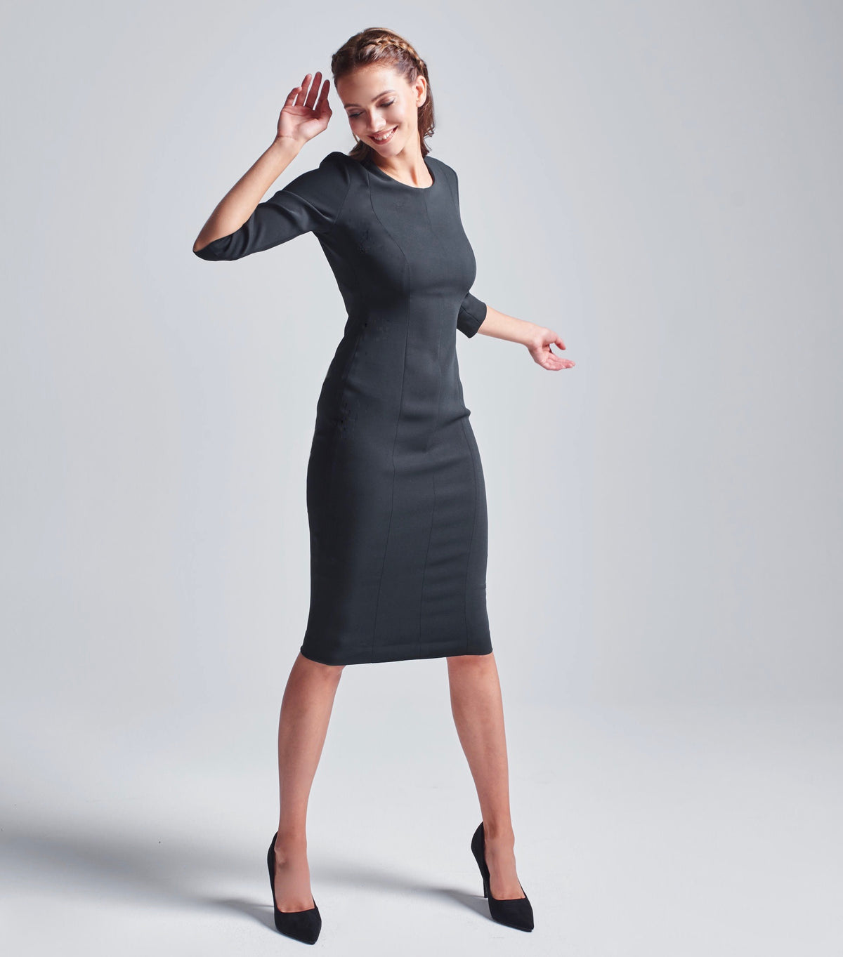 Schwarzes  Multiplyfashion Bleistiftkleid mit schmalem 3/4 Ärmel aus Viskose-Mischgewebe mit einem etwas über dem Knie endenden Saum. Vorderansicht des Models mit figurbetontem Bleistiftkleid in Kombination mit schwarzen, eleganten Pumps.