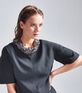 Das Model trägt den abnehmbaren Paillettenkragen in goldfarben auf dem schwarzen Multiplyfashion Shift-Oberteil.