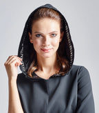 Das Model trägt den abnehmbaren Kapuzenkragen auf dem Multiplyfashion Shift-Kleid. Diese Nahaufnahme zeigt den Kopf mit der oben getragenen Kapuze.