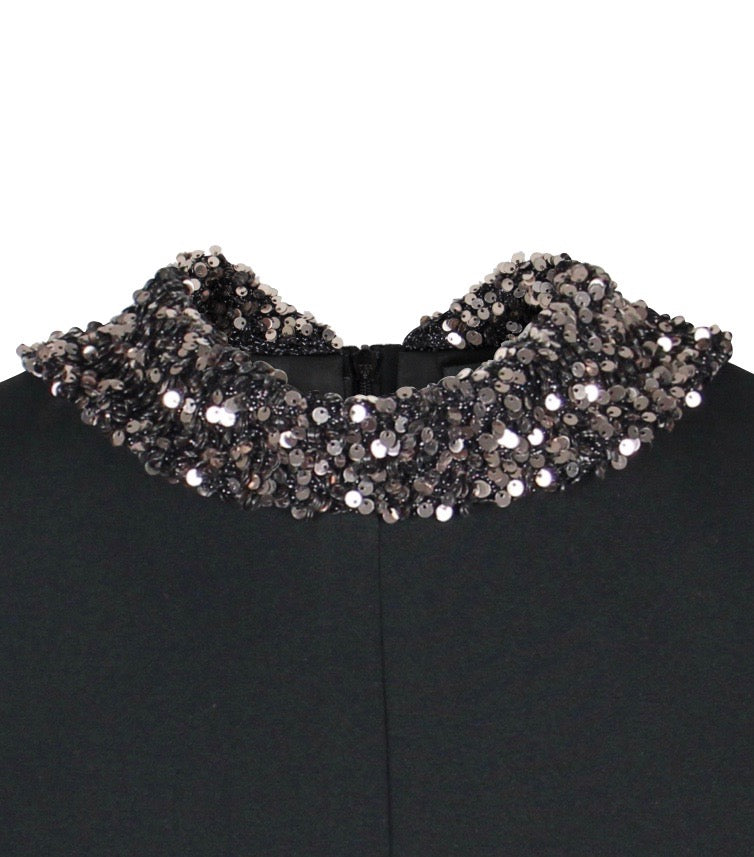 Abnehmbarer Paillettenkragen in goldfarben auf dem schwarzen Multiplyfashion Shift-Oberteil.
