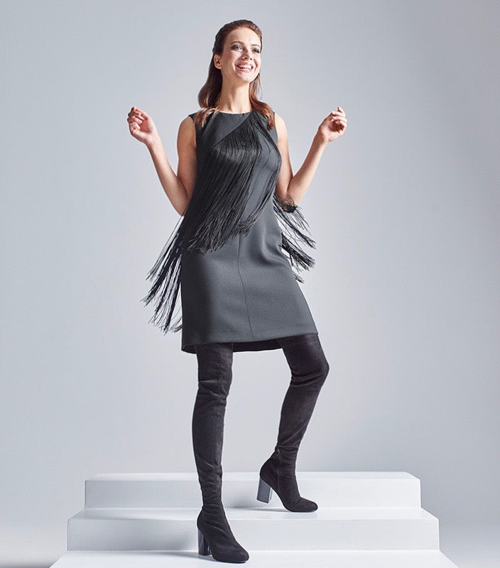 Das Model trägt den abnehmbaren Multiplyfashion Fransenkragen in Kombination mit dem schwarzen Multiplyfashion Etuikleid.
