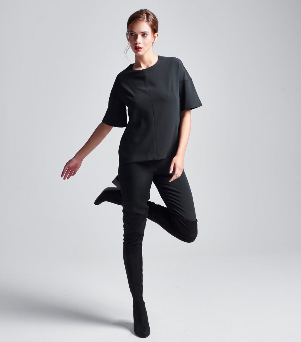 Schwarzes Multiplyfashion Shift Oberteil kombiniert mit der eng anliegenden Multiplyfashion Hose und Overknee-Stiefeln. 